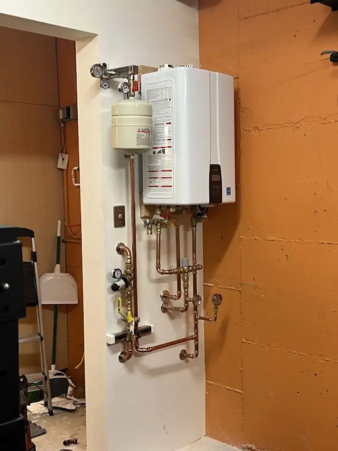Plumbing technician inspecting water heater connections in Glendive